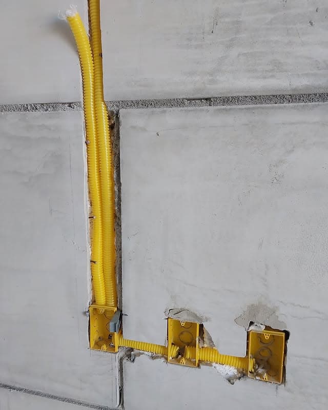Instalación eléctrica con conduit amarillo en pared BLOCOBR